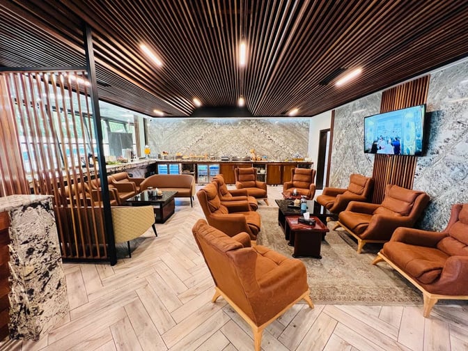 The Baghdad Lounge at Baghdad International Airport features comfortable seating, a television, and a refreshment area with self-serve options.