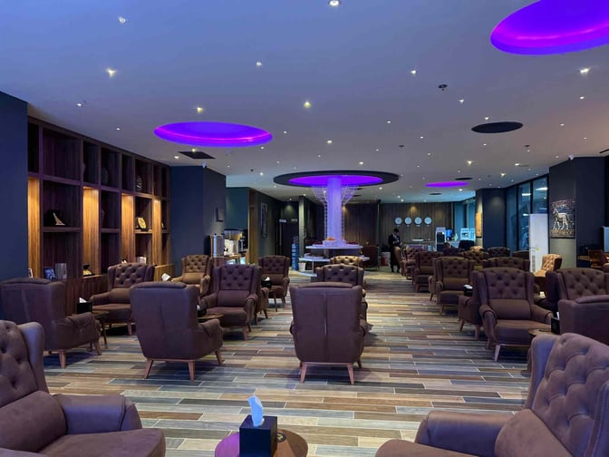 The Iraqi Lounge at Baghdad International Airport features plush seating with tables, offering a spacious area for relaxation and comfort.
