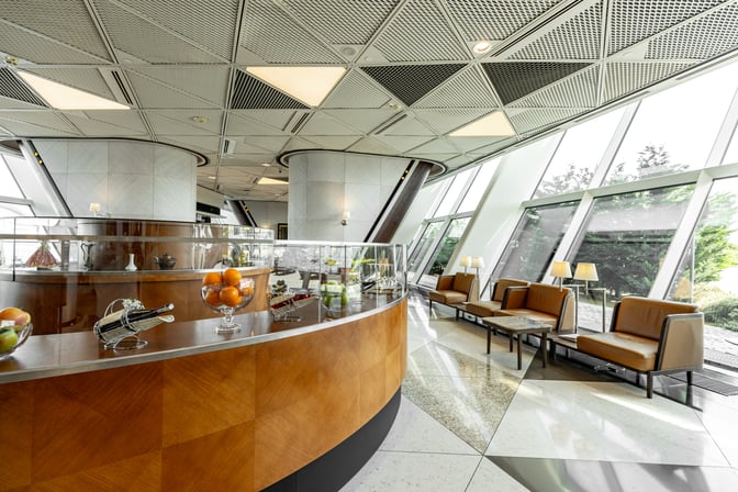 The Salam Lounge at Heydar Aliyev International Airport features a seating area with armchairs and tables, adjacent to a counter displaying fruits and beverages.
