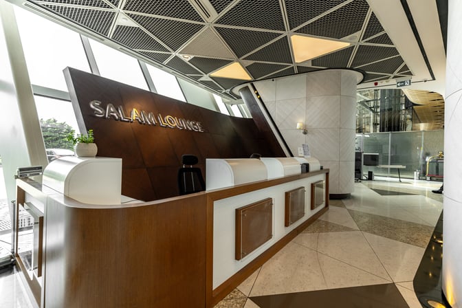 The Salam Lounge entrance at Heydar Aliyev International Airport features a reception desk with signage, located near large windows.
