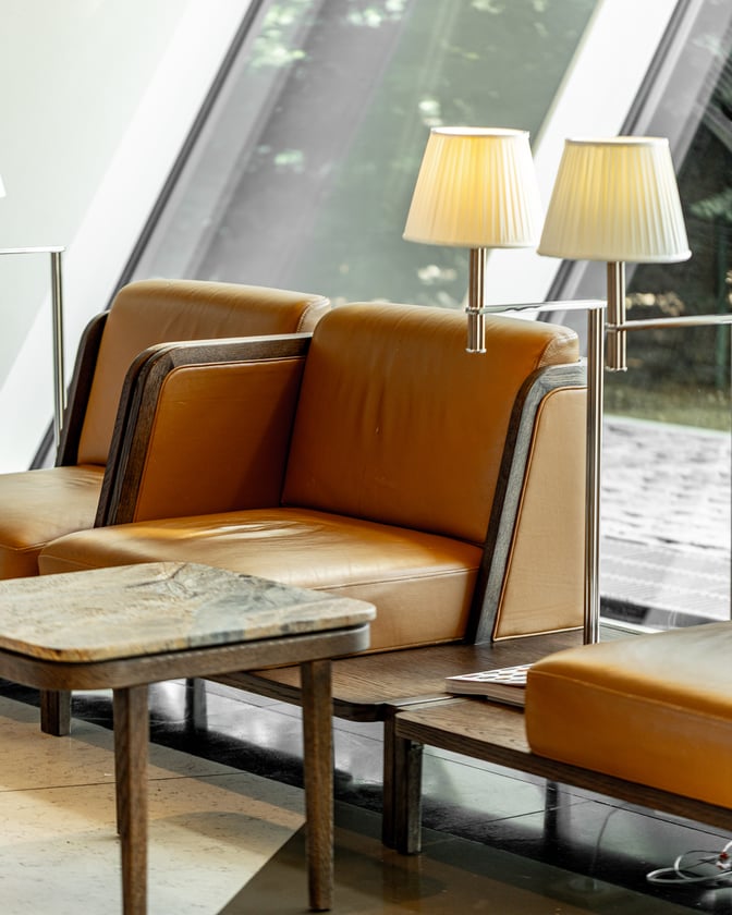 Seating area in Salam Lounge at Heydar Aliyev International Airport features cushioned chairs, small tables, and individual lamps for passenger comfort.