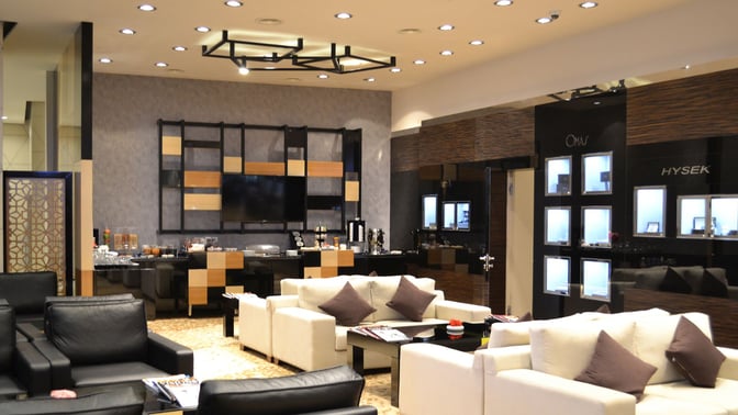 The Baku Club lounge at Heydar Aliyev International Airport features comfortable seating and a self-serve snack area with various refreshments.