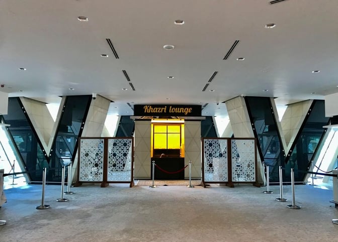 The entrance to Khazri Lounge at Heydar Aliyev International Airport features decorative panels and a reception area with roped barriers.