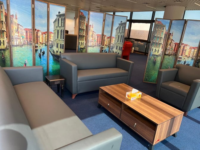 The Roumieh Business Lounge at Banjul International Airport features a seating area with sofas and decorative partition screens.