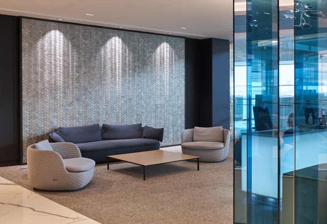 The seating area in Sala VIP Miró at Barcelona Airport features comfortable chairs and a sofa around a central table.