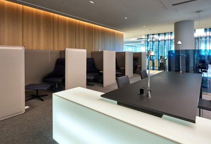 The Sala VIP Miró at Barcelona Airport features semi-private seating pods and a work area with desk lamps for travelers.