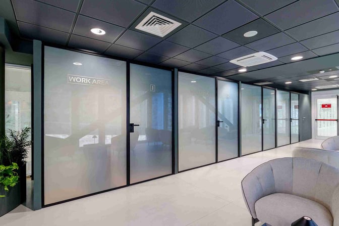 Private work areas at Bari Karol Wojtyła Airport lounge offer individual enclosed spaces for focused tasks, adjacent to comfortable seating.