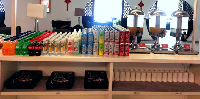 The beverage station at Beijing Capital International Airport's Easy Lounge offers a variety of bottled drinks and juice dispensers.