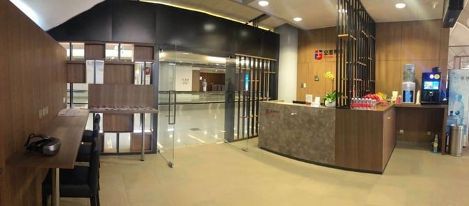 The CIP International Lounge entrance at Beijing Capital International Airport features a reception desk and a self-serve beverage station.