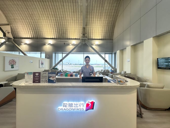 The reception desk at CIPB2 Lounge, Beijing Capital International Airport, features seating areas and flight information displays for travelers.