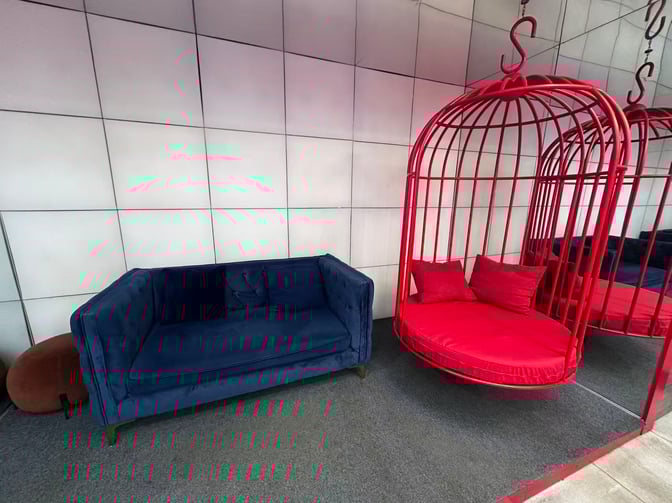 The Barcelo Lounge at Beijing Capital International Airport features a seating area with a sofa and a unique hanging chair.