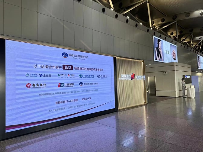 The entrance to the Beijing Capital V6 Lounge at Beijing Capital International Airport features a large digital display and branded signage.