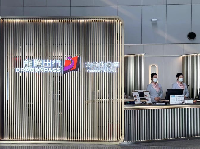 The entrance to the DragonPass Members Lounge at Beijing Capital International Airport features a reception desk staffed by attendants.