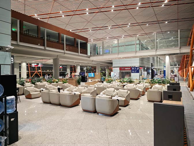 The CIP International Lounge at Beijing Capital International Airport features a spacious seating area with armchairs and tables for travelers.
