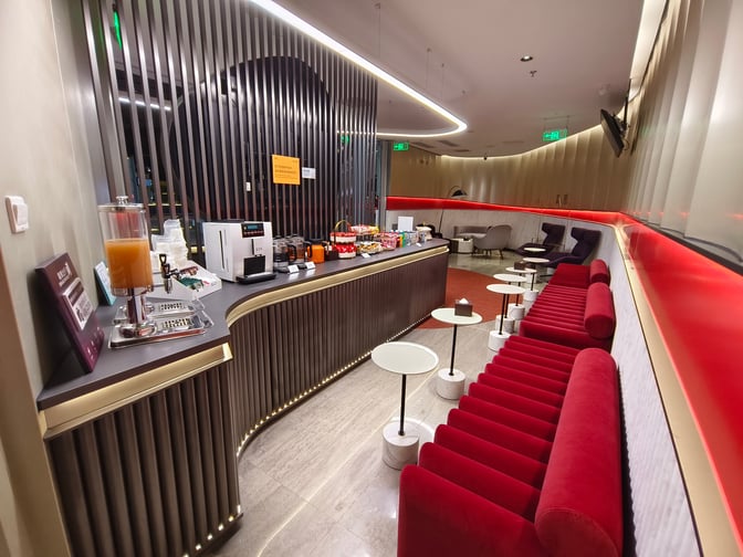 The Airport Club A2 Members Lounge at Beijing Capital International Airport features a self-serve beverage and snack station with seating.