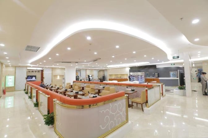 The Trvok A1 Lounge at Beijing Capital International Airport features a spacious seating area with tables and a self-serve beverage station.