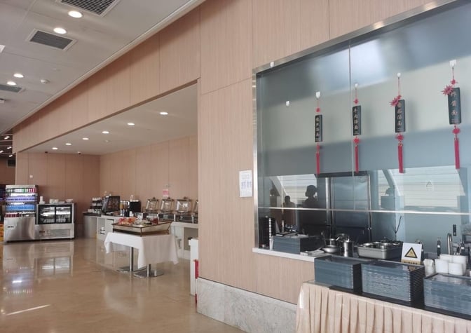The China Eastern Lounge at Beijing Capital International Airport features a self-serve food area with hot dishes and beverage options.