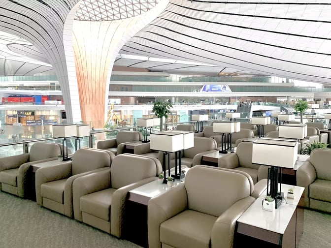 Comfortable seating with individual tables and lamps is available in the BCS Domestic Premier Lounge at Beijing Daxing International Airport.