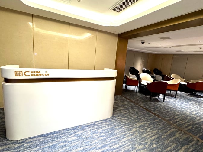 The CHUM Guest 79 Lounge at Beijing Daxing International Airport features a reception desk and a seating area with armchairs.