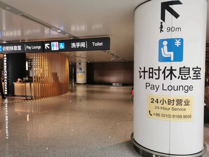 The entrance to the Pay Lounge at Beijing Daxing International Airport features signage for 24-hour service and nearby facilities.