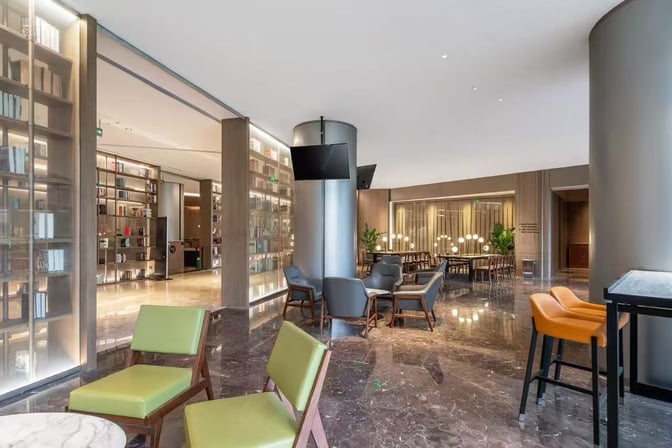 The Meichen VIP Lounge at Beijing Daxing International Airport features a seating area with chairs, tables, and a visible bookshelf.