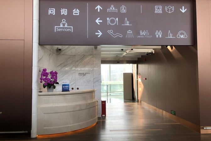 The entrance to the V3 China Eastern Lounge at Beijing Daxing International Airport features a service desk and directional signage.