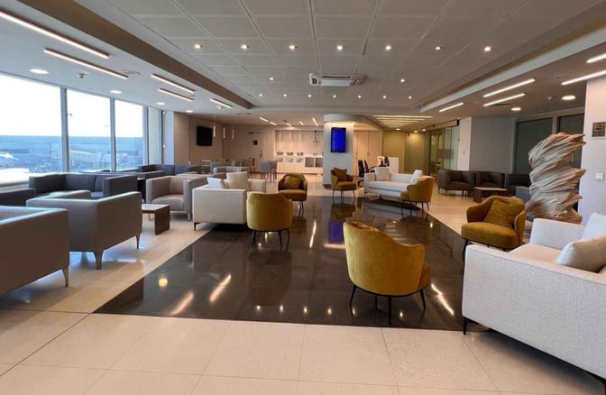 The Ahlein Comfy Lounge at Beirut Airport features a spacious seating area with various chairs and sofas, offering airport views.