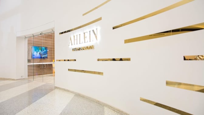 The entrance to Ahlein Premium Lounge at Beirut Airport features glass doors and a visible digital display inside.