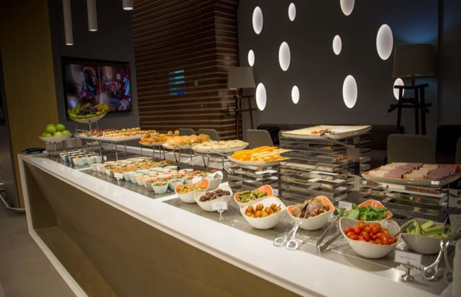 The buffet area at Ahlein Premium Lounge in Beirut Airport offers a variety of self-serve salads, fruits, and pastries.