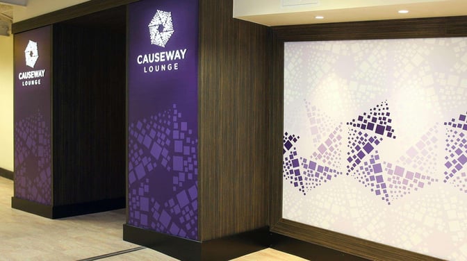 The entrance to the Causeway Lounge at Belfast International Airport features prominent signage and geometric wall patterns.