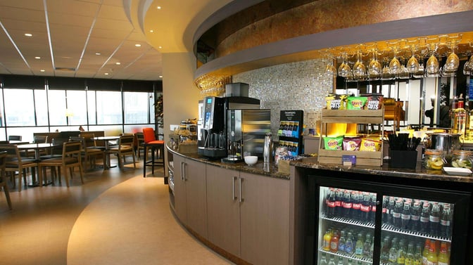 The Causeway Lounge at Belfast International Airport features a self-serve snack and beverage area with seating for dining and relaxation.