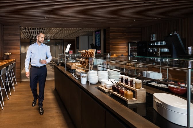 The Lounge Tegel at Berlin Brandenburg Airport features a self-serve food area with plates, condiments, and a variety of breakfast options.