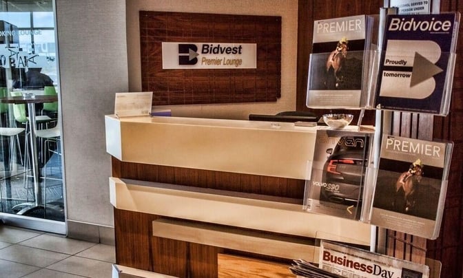 The reception area of the Bidvest Premier Lounge at East London Airport features a check-in counter and magazine display.