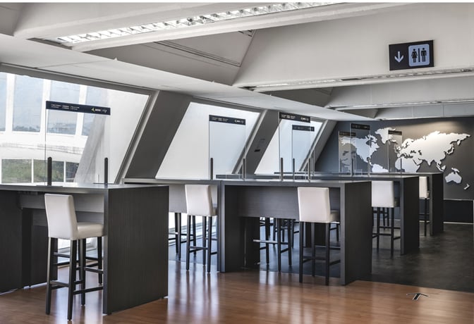 High tables with bar stools in the Nervión VIP Lounge at Bilbao Airport offer seating with views of the tarmac.