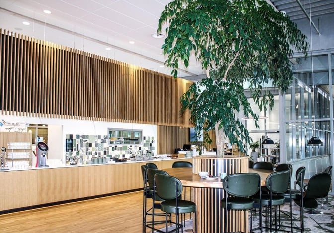 The King Amlet Lounge at Billund Airport features a self-serve food area with counter seating and a central communal table.