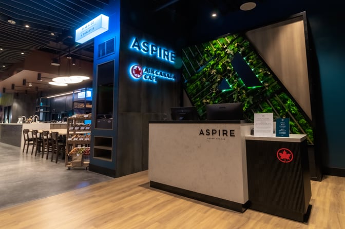 The entrance to the Aspire Air Canada Cafe at Billy Bishop Toronto City Airport features a reception desk and a vertical garden.