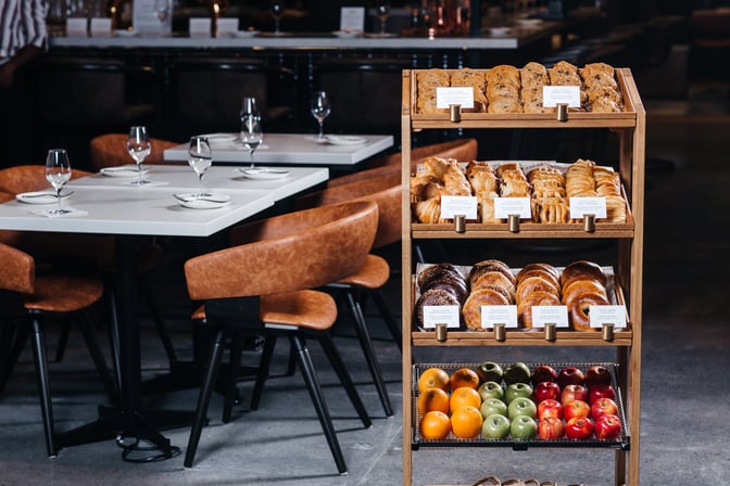 A self-serve pastry and fruit station at Aspire Air Canada Cafe offers a variety of baked goods and fresh fruits.