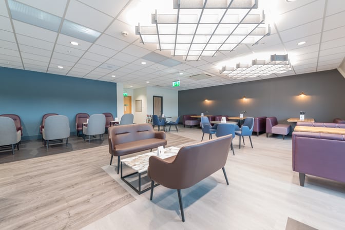 The Aspire Lounge South at Birmingham Airport features varied seating options, including sofas and chairs, arranged around small tables for relaxation.
