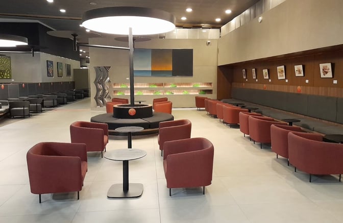 The Avianca Lounge at El Dorado International Airport features a spacious seating area with armchairs and tables for travelers.