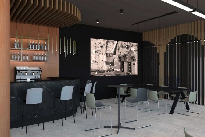 The Prima Vista Lounge at Bologna Airport features a bar with seating and a coffee machine, alongside tables for dining.