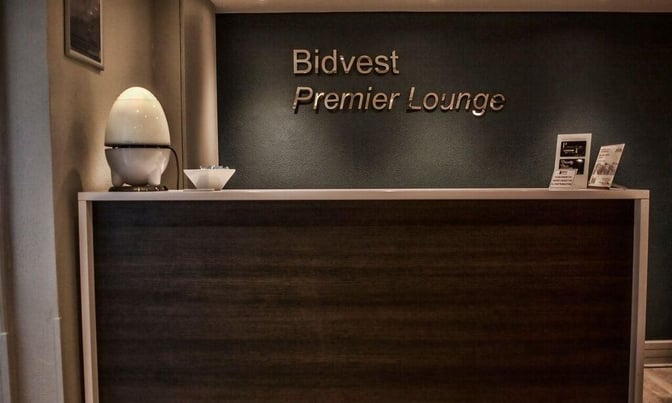 The reception area of Bidvest Premier Lounge at Bram Fischer International Airport features a check-in counter with informational brochures.