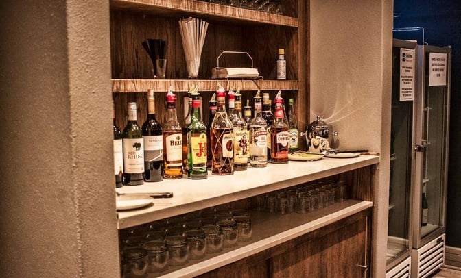 The Bidvest Premier Lounge at Bram Fischer International Airport features a self-serve bar with a selection of spirits and glassware.