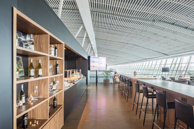 The VIP Express Club Pier Sul at Brasilia International Airport features a buffet area with high-top seating and panoramic airport views.