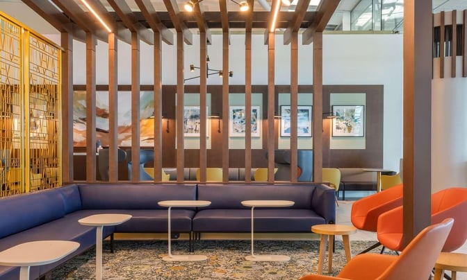 The seating area in Brisbane Airport's Escape Lounge features comfortable chairs and tables, providing a relaxing space for travelers.