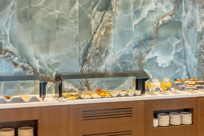 The Escape Lounge at Brisbane Airport features a self-serve food station with a variety of snacks and sandwiches available.