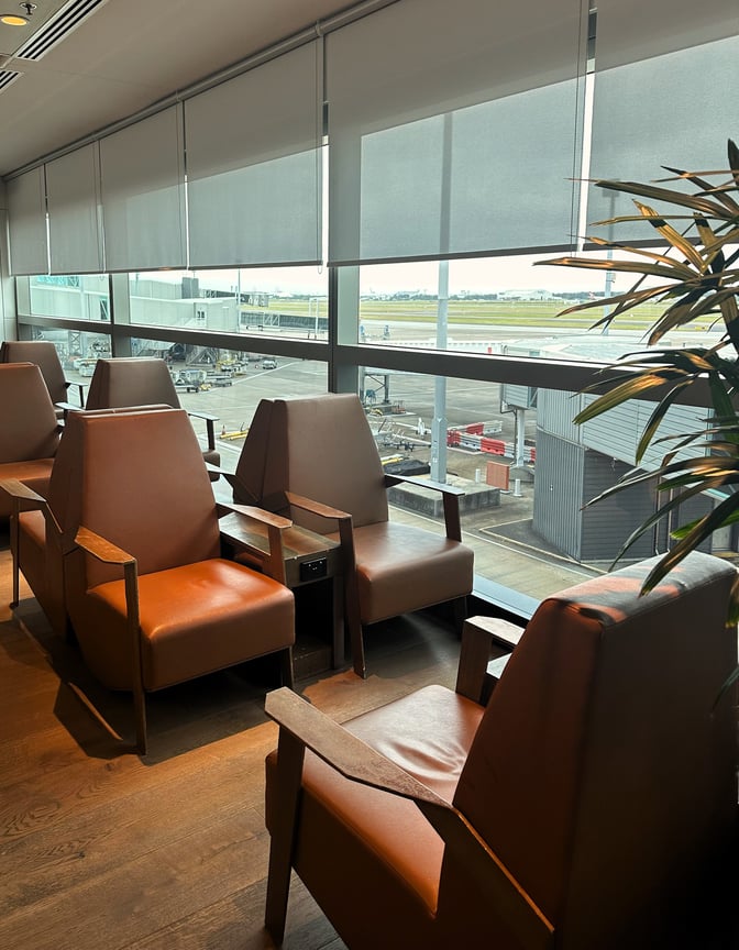 Seating in the Plaza Premium Lounge at Brisbane Airport offers comfortable chairs with views of the tarmac through large windows.