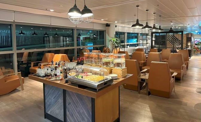 The Plaza Premium Lounge at Brisbane Airport features a self-serve food station with seating areas for travelers to relax.