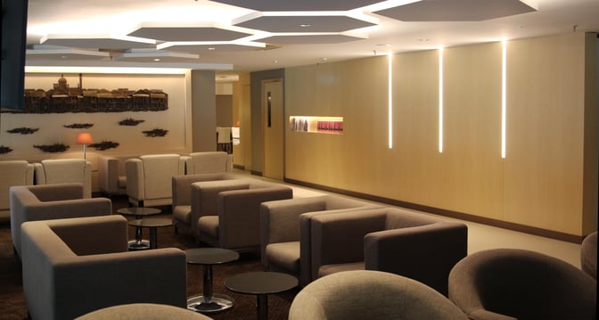 The seating area in Royal Brunei's Sky Lounge at Brunei International Airport offers comfortable armchairs and small tables for travelers.