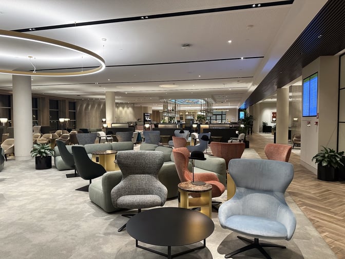 The seating area at The View lounge in Brussels Airport features various chairs and tables, providing a comfortable space for travelers.