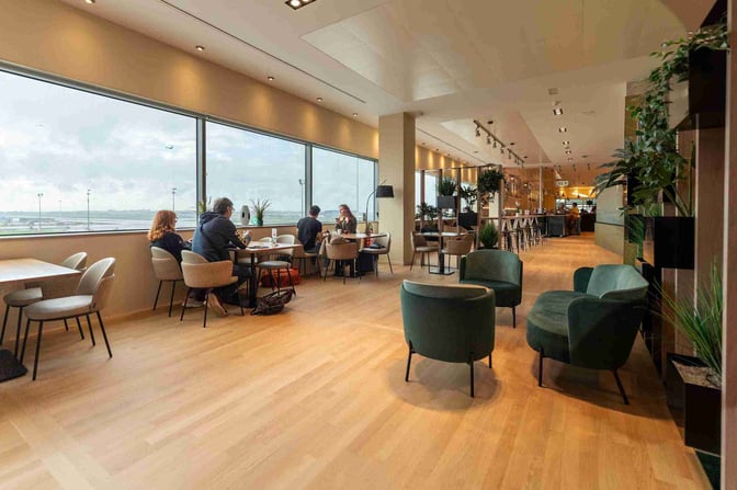 The Diamond Lounge at Brussels Airport features seating with airport views and a bar area offering refreshments.